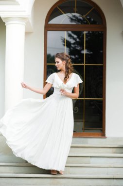 Düğün seremonisinden önce beyaz sarayın yakınında açık renkli, uzun beyaz elbiseli zarif bir kadın yürüyordu..