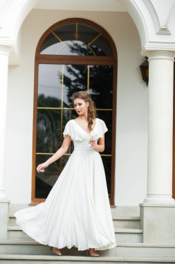 Düğün seremonisinden önce beyaz sarayın yakınında açık renkli, uzun beyaz elbiseli zarif bir kadın yürüyordu..