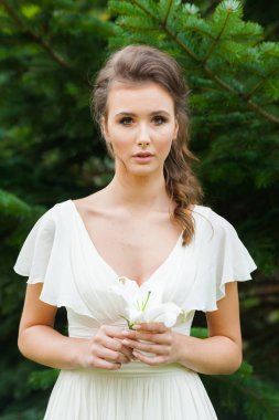 Düğün seremonisinden önce beyaz sarayın yakınında açık renkli, uzun beyaz elbiseli zarif bir kadın yürüyordu..