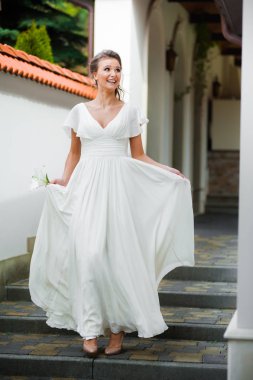 Düğün seremonisinden önce beyaz sarayın yakınında açık renkli, uzun beyaz elbiseli zarif bir kadın yürüyordu..