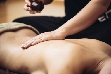 Profesyonel bir masaj terapisti tarafından bir güzellik salonunun rahat atmosferinde yapılan duygusal tantrik masaj.