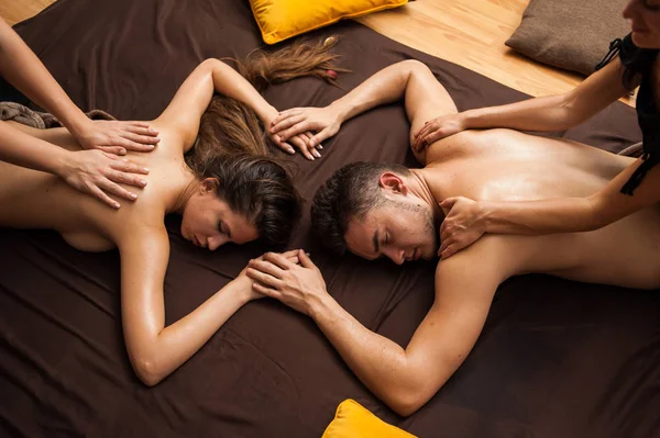 Relaxing massage for a couple in four hands. Four-handed massage is a massage where two therapists work on you at the same time, mirroring each others.