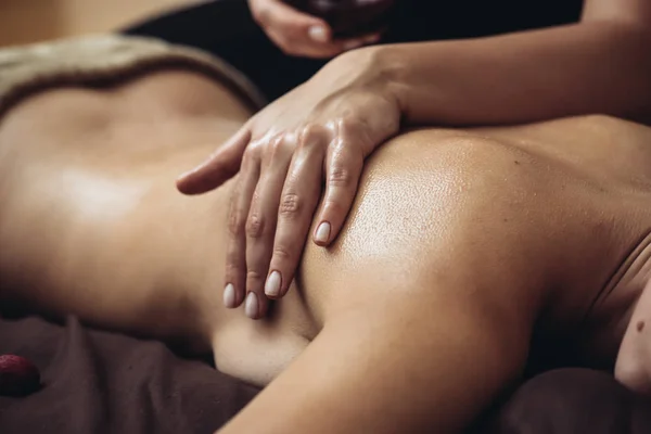 Sensual tantric massage in the cozy atmosphere of a beauty salon by a professional massage therapist