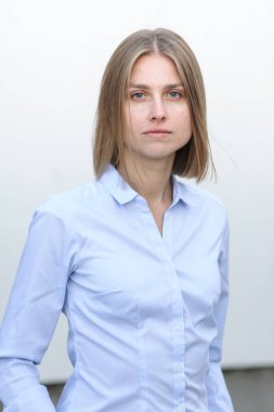 Beyaz duvarın arkasında çalışan başarılı genç bir kadının portresi.