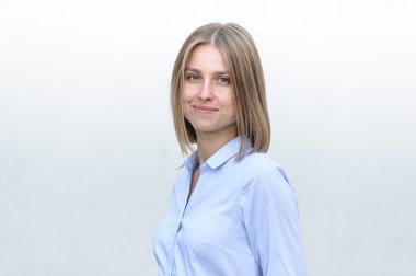 Beyaz duvarın arkasında çalışan başarılı genç bir kadının portresi.