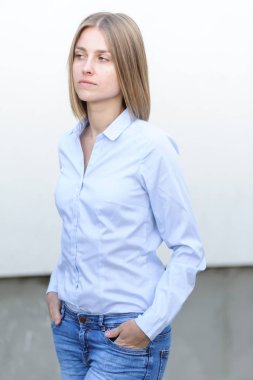 Beyaz duvarın arkasında çalışan başarılı genç bir kadının portresi.