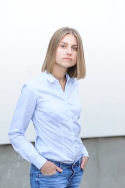 Beyaz duvarın arkasında çalışan başarılı genç bir kadının portresi.