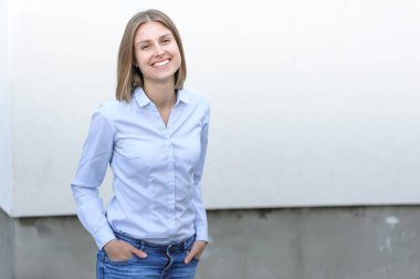 Beyaz duvarın arkasında çalışan başarılı genç bir kadının portresi.