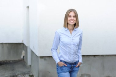 Beyaz duvarın arkasında çalışan başarılı genç bir kadının portresi.