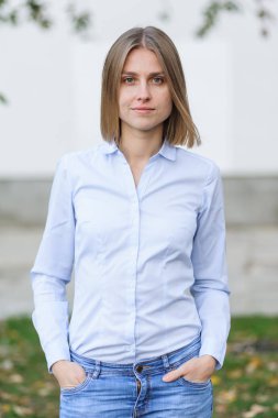 Beyaz duvarın arkasında çalışan başarılı genç bir kadının portresi.