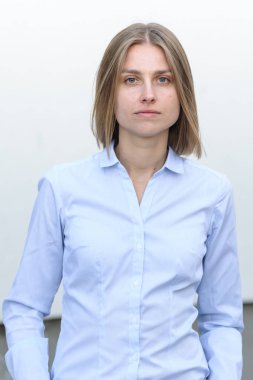 Beyaz duvarın arkasında çalışan başarılı genç bir kadının portresi.