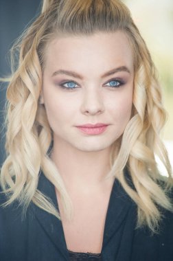 Güzel sarışın, mavi gözlü ve dalgalı saçlı.