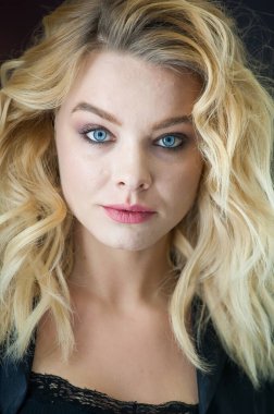 Güzel sarışın, mavi gözlü ve dalgalı saçlı.