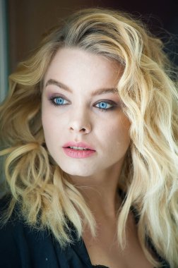 Güzel sarışın, mavi gözlü ve dalgalı saçlı.