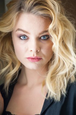 Güzel sarışın, mavi gözlü ve dalgalı saçlı.