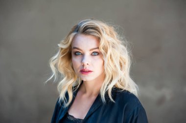 Güzel sarışın, mavi gözlü ve dalgalı saçlı.