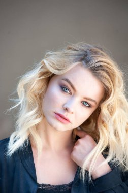 Güzel sarışın, mavi gözlü ve dalgalı saçlı.