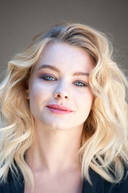 Güzel sarışın, mavi gözlü ve dalgalı saçlı.