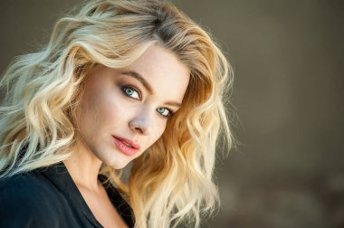 Güzel sarışın, mavi gözlü ve dalgalı saçlı.