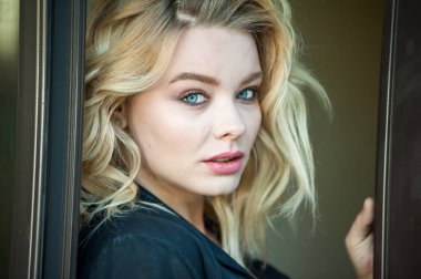 Güzel sarışın, mavi gözlü ve dalgalı saçlı.