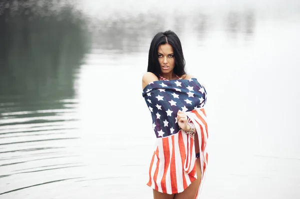 ビーチでアメリカ国旗と水着の美しいフィットネス若い女性 — ストック写真