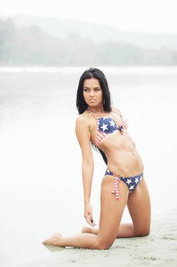 Amerika 'nın Bağımsızlık Günü' nü kutlayan neşeli kadın kumsalda Amerikan bayrağıyla