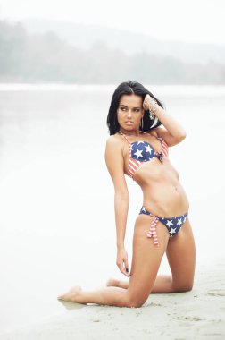 Amerika 'nın Bağımsızlık Günü' nü kutlayan neşeli kadın kumsalda Amerikan bayrağıyla