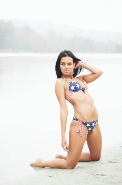 Amerika 'nın Bağımsızlık Günü' nü kutlayan neşeli kadın kumsalda Amerikan bayrağıyla