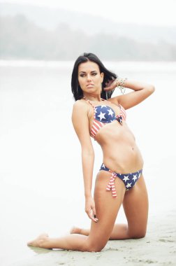 Amerika 'nın Bağımsızlık Günü' nü kutlayan neşeli kadın kumsalda Amerikan bayrağıyla