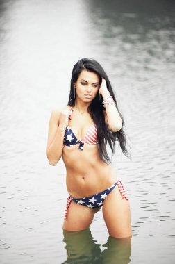 Amerika 'nın Bağımsızlık Günü' nü kutlayan neşeli kadın kumsalda Amerikan bayrağıyla