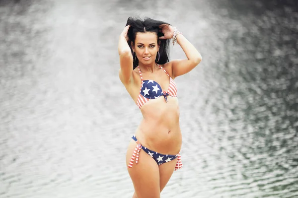 美丽健康的年轻女子穿着泳衣 海滩上挂着美国国旗 — 图库照片