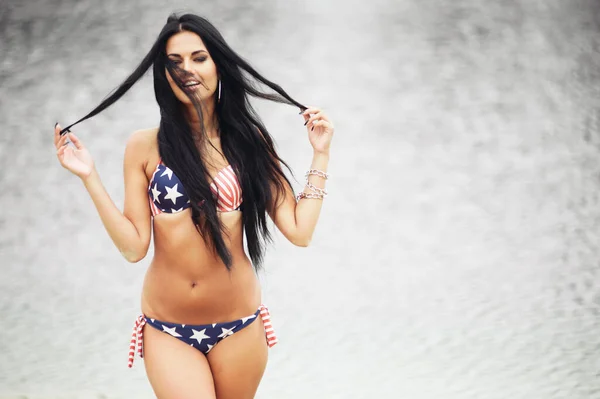 アメリカ独立記念日を祝う陽気な女性アメリカの国旗とビーチで — ストック写真
