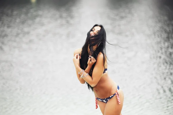 在海滩上举着美国国旗庆祝美国独立日的快乐女人 — 图库照片