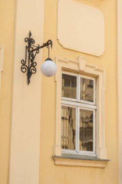 Duvarda eski model bir fener var.