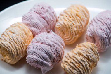 Koyu bir arka planda tabakta leziz marşmelovlar.