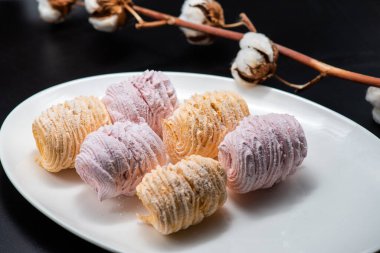 Koyu bir arka planda tabakta leziz marşmelovlar.