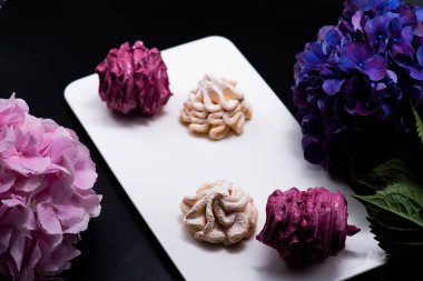 Koyu bir arka planda tabakta leziz marşmelovlar.