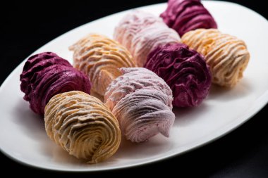 Koyu bir arka planda tabakta leziz marşmelovlar.