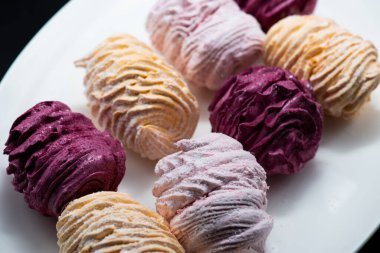 Koyu bir arka planda tabakta leziz marşmelovlar.