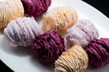 Koyu bir arka planda tabakta leziz marşmelovlar.