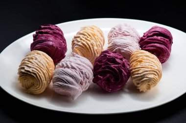 Koyu bir arka planda tabakta leziz marşmelovlar.