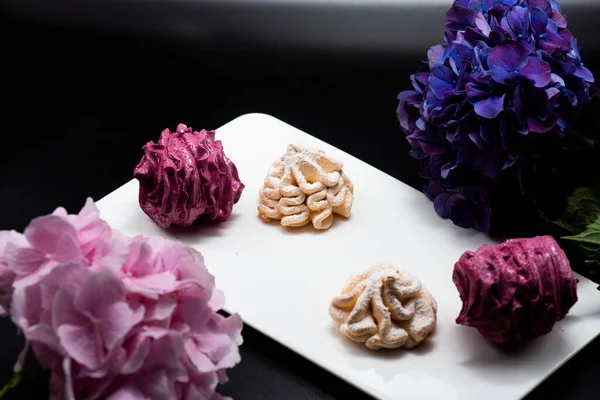 Koyu bir arka planda tabakta leziz marşmelovlar.