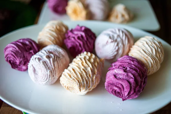 Koyu bir arka planda tabakta leziz marşmelovlar.