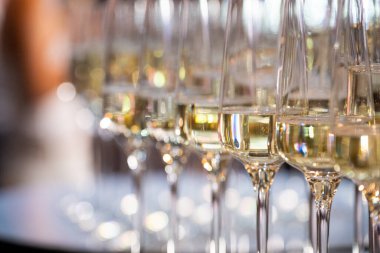 Beyaz şarabın arka planında bir kadeh şampanya.