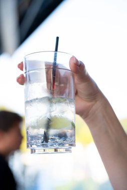 El ele tutuşup, arka planda su olan buzlu cam.