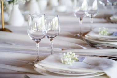 Düğün masası süslemeleri, bardaklar, mumlar ve çiçeklerle.