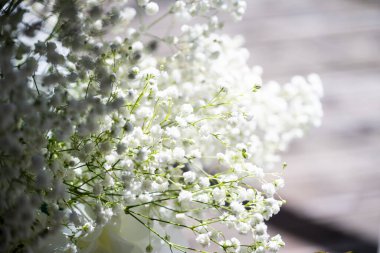 Tahta arka planda beyaz çiçekler, düğün töreni için güzel bir dekor.