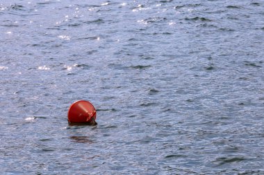Denizin ortasında yüzen kırmızı şamandıra.