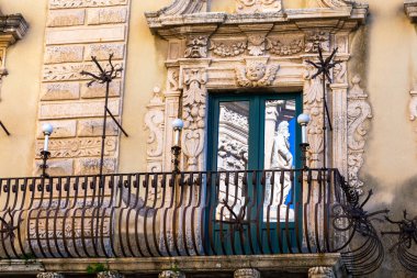 Pencereye yansıyan barok heykel.