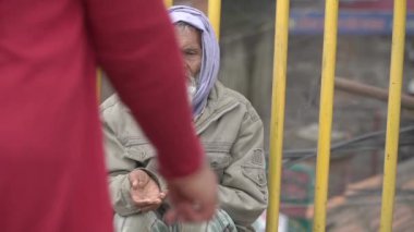 Dilenci para için yalvarır